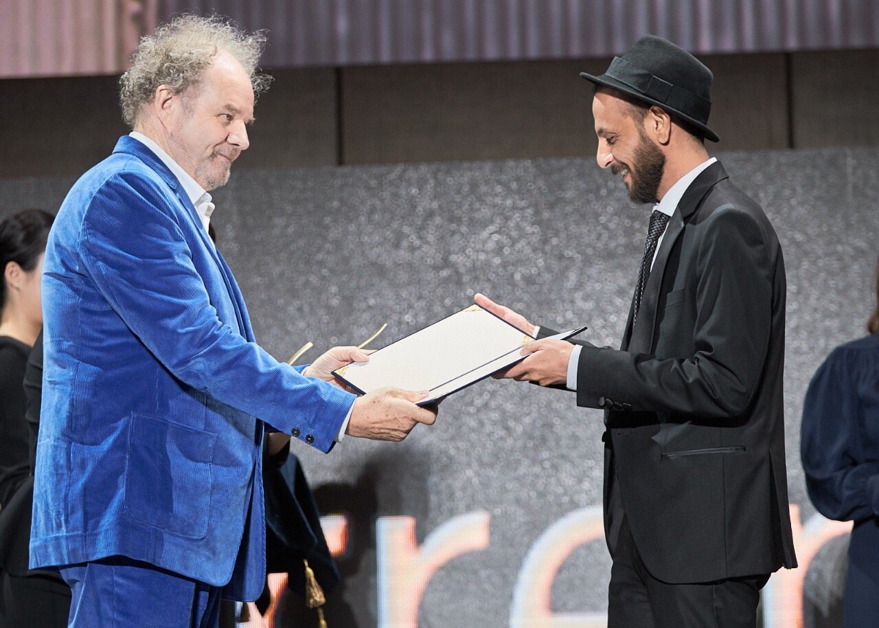 Mohanad Hayal receiving the New Currents Award on stage at the Busan International Film Festival